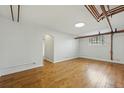 Spacious living space featuring hardwood floors, arched doorways, a window, and exposed piping at 3132 E 17Th Ave # B, Denver, CO 80206