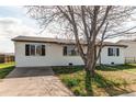 Exterior view of home with concrete driveway, trimmed lawn, and tidy siding at 280 Birch St, Bennett, CO 80102