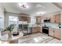 Eat-in kitchen featuring stainless appliances, wood cabinets, modern lighting, and gray backsplash at 280 Birch St, Bennett, CO 80102