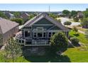 Well-maintained home featuring an expansive deck, lush lawn, and meticulous landscaping at 6699 S Robb St, Littleton, CO 80127