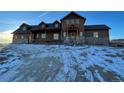 Spacious brown home featuring a stone foundation and welcoming front porch at 2710 Rustlers Canyon Loop, Elizabeth, CO 80107