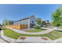 Well-kept side yard featuring lush green grass, a wooden fence, and easy access to the home's entrance at 4776 Kipp Pl, Brighton, CO 80601