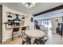 Open concept kitchen and dining area with stainless appliances, white cabinets, breakfast bar, and modern lighting at 12131 Melody Dr # 201, Denver, CO 80234