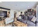 Comfortable living room with a plush sofa, accent chair, wood floors, and stylish décor at 12131 Melody Dr # 201, Denver, CO 80234