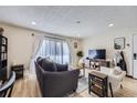 Cozy living room featuring a comfortable sofa, TV, and natural light from the sliding doors at 12131 Melody Dr # 201, Denver, CO 80234