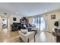 Comfortable living area featuring a gray sofa, white accent chair, workspace, and natural light from sliding glass doors at 12131 Melody Dr # 201, Denver, CO 80234