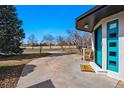 Bright blue front door, lush green trees and expansive driveway create a warm welcome at 1270 S Lowell Blvd, Denver, CO 80219