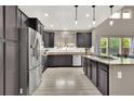Modern kitchen with stainless steel appliances, dark cabinetry, and bright lighting at 11670 S Flower Mound Way, Parker, CO 80134