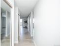 Bright hallway with light wood floors, mirrored closet door, and an open view into the living area at 9155 E Center Ave # 4B, Denver, CO 80247