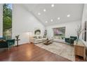 Bright living room featuring a vaulted ceiling, large picture window, and hardwood flooring at 8424 E Otero Cir, Centennial, CO 80112