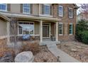Charming front porch with stone accents, comfortable seating, and a well-maintained walkway at 4810 Mountain Gold Run, Broomfield, CO 80023