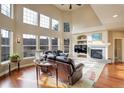 Bright living room featuring hardwood floors, a fireplace, and large windows at 4810 Mountain Gold Run, Broomfield, CO 80023