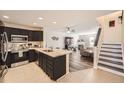 Modern kitchen with black cabinets, stainless steel appliances and granite counters is open to the Gathering room at 5075 Garrison St # 3, Wheat Ridge, CO 80033