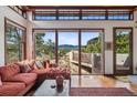 Cozy living room featuring large windows with scenic mountain views and hardwood flooring at 6767 Timbers Dr, Evergreen, CO 80439