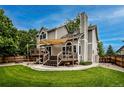 Home backyard featuring a wooden deck with a sunshade, green lawn, and partial fence under a blue sky at 6255 Collegiate Dr, Highlands Ranch, CO 80130