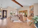 Bright living room with stone fireplace, vaulted ceiling, hardwood floors, view, and natural light from large windows and sliding doors at 1374 Crested Butte Ct, Evergreen, CO 80439