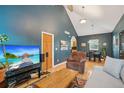 Open-concept living room with hardwood floors, vaulted ceiling, and an inviting archway to the kitchen at 2203 S Lincoln St, Denver, CO 80210