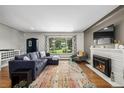 Bright living room with a fireplace, hardwood floors, and a large window at 2845 Hudson St, Denver, CO 80207