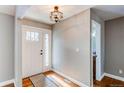 Inviting foyer with hardwood floors, a glass-paneled front door, and modern light fixture at 7163 S Xanthia St, Centennial, CO 80112