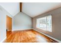 Bright living room featuring hardwood floors, a vaulted ceiling, and a large window at 7163 S Xanthia St, Centennial, CO 80112