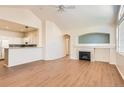 Bright living room featuring a fireplace, ceiling fan, and wood-look floors at 8843 W Phillips Dr, Littleton, CO 80128