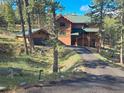 A beautiful log home with a well manicured lawn and driveway located in a tranquil neighborhood at 6241 Kilimanjaro Dr, Evergreen, CO 80439