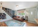 Bright living room features stylish decor, hardwood floors, and an open staircase at 2595 S Irving St, Denver, CO 80219