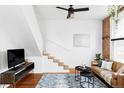 Modern living room featuring hardwood floors, a brick wall, and stairs to the second floor at 2909 Glenarm Pl, Denver, CO 80205