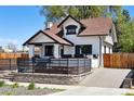 Quaint two-story home with black trim, showcasing its charming architecture and landscaped front yard at 1484 Cherry St, Denver, CO 80220