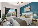Cozy bedroom featuring a queen-size bed, stylish decor, and a large window with neighborhood views at 9633 E 5Th Ave # 10208, Denver, CO 80230