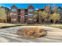 Brick apartment building with balconies and landscaped courtyard at 9633 E 5Th Ave # 10208, Denver, CO 80230