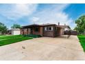 Charming single-story home featuring a brick facade, covered porch, and a convenient carport at 3334 W Grand Ave, Englewood, CO 80110