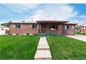 A quaint single-story brick home with a well-manicured lawn, covered porch, and walkway at 3334 W Grand Ave, Englewood, CO 80110