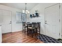 Cozy dining area boasts a modern chandelier, wainscoting, and convenient access to the exterior at 3937 S Truckee St, Aurora, CO 80013