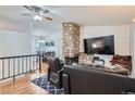 Bright living room featuring a stone fireplace, hardwood floors, and an adjacent dining area at 3937 S Truckee St, Aurora, CO 80013
