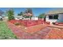 A spacious backyard perfect for entertaining with an umbrella, red fence and patio at 2401 W Jewell Ave, Denver, CO 80219