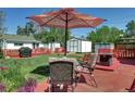 Relaxing backyard with a patio set under a striped umbrella, and a well-maintained lawn, perfect for outdoor enjoyment at 2401 W Jewell Ave, Denver, CO 80219