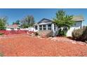 Charming home featuring a stone accent and cozy red rock landscaping at 2401 W Jewell Ave, Denver, CO 80219