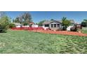 Charming home featuring a well-maintained lawn and inviting front porch with a red fence at 2401 W Jewell Ave, Denver, CO 80219