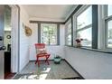 Cozy sun room with ample natural light, accentuated by white walls and a charming red accent chair for relaxation at 2401 W Jewell Ave, Denver, CO 80219
