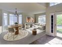 Bright living room featuring a round dining table, comfortable seating, and large windows at 331 Las Lomas St, Brighton, CO 80601
