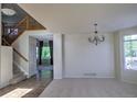 Open living room and stairway featuring carpet, neutral paint, and plenty of natural light at 331 Las Lomas St, Brighton, CO 80601