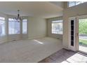 Bright living room with neutral carpet, many windows, and access to the back yard at 331 Las Lomas St, Brighton, CO 80601