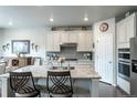 Kitchen with granite countertops, stainless steel appliances, white cabinets and barstool seating at 3936 Costillo Ct, Brighton, CO 80601