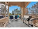 A covered patio with outdoor seating and grill, perfect for entertaining and enjoying the scenic views at 9132 Scenic Pine Dr, Parker, CO 80134