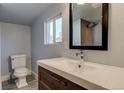 Modern bathroom featuring a vanity sink with chrome faucet and visible commode and window at 915 N Irving St, Denver, CO 80204