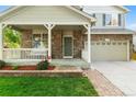 Close up of home exterior with a stone facade, covered porch, and beautifully landscaped front yard at 14794 Vine St, Thornton, CO 80602
