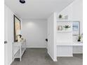 Hallway featuring built-in desk, shelving, neutral paint, and gray carpet leading up the stairs at 221 S Garfield St # 213, Denver, CO 80209