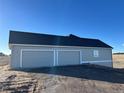 View of a large three car garage with light gray doors at 270 High Meadows Loop, Elizabeth, CO 80107