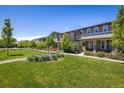 A row of townhomes overlooks a well-manicured green space with mature trees and a walking path at 11033 E 28Th Pl, Denver, CO 80238